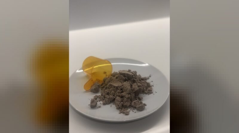 Chocolate flavoured pea protein powder pictured with its serving scoop.