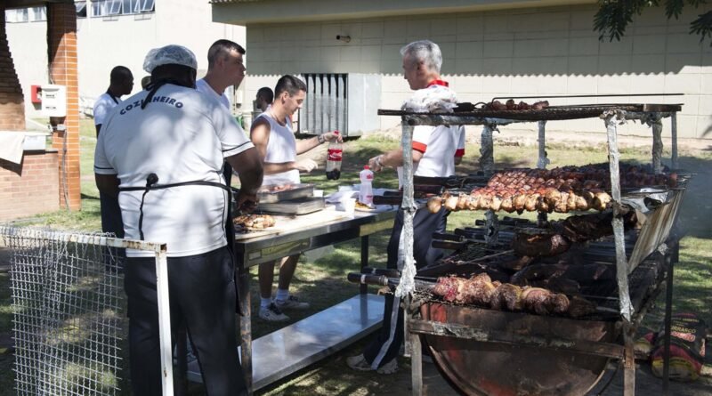 Brazilian navy chefs prepare grilled meat for a barbecue after a friendly soccer match between Sailors assigned to future amphibious assault ship USS