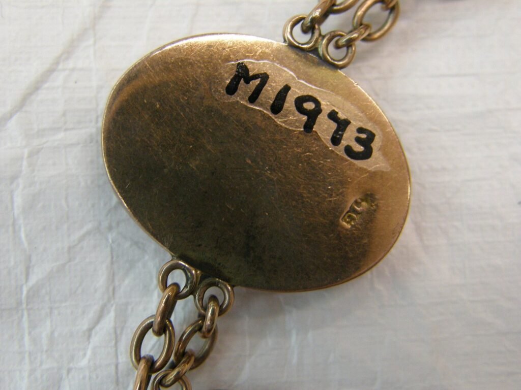 Bracelet comprising one large and five smaller gemstones set in gold and joined by double row of chain links.